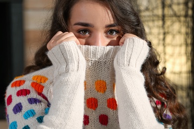 Photo of Portrait of young beautiful woman in warm sweater at home