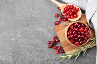 Photo of Fresh ripe cranberries and rosemary on grey table, flat lay. Space for text