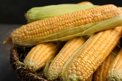 Photo of Basket with tasty sweet corn cobs, closeup