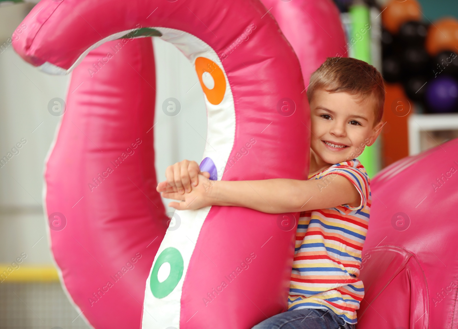 Photo of Cute little child playing at indoor amusement park