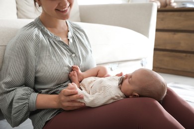 Happy mother with her cute sleeping baby at home, closeup