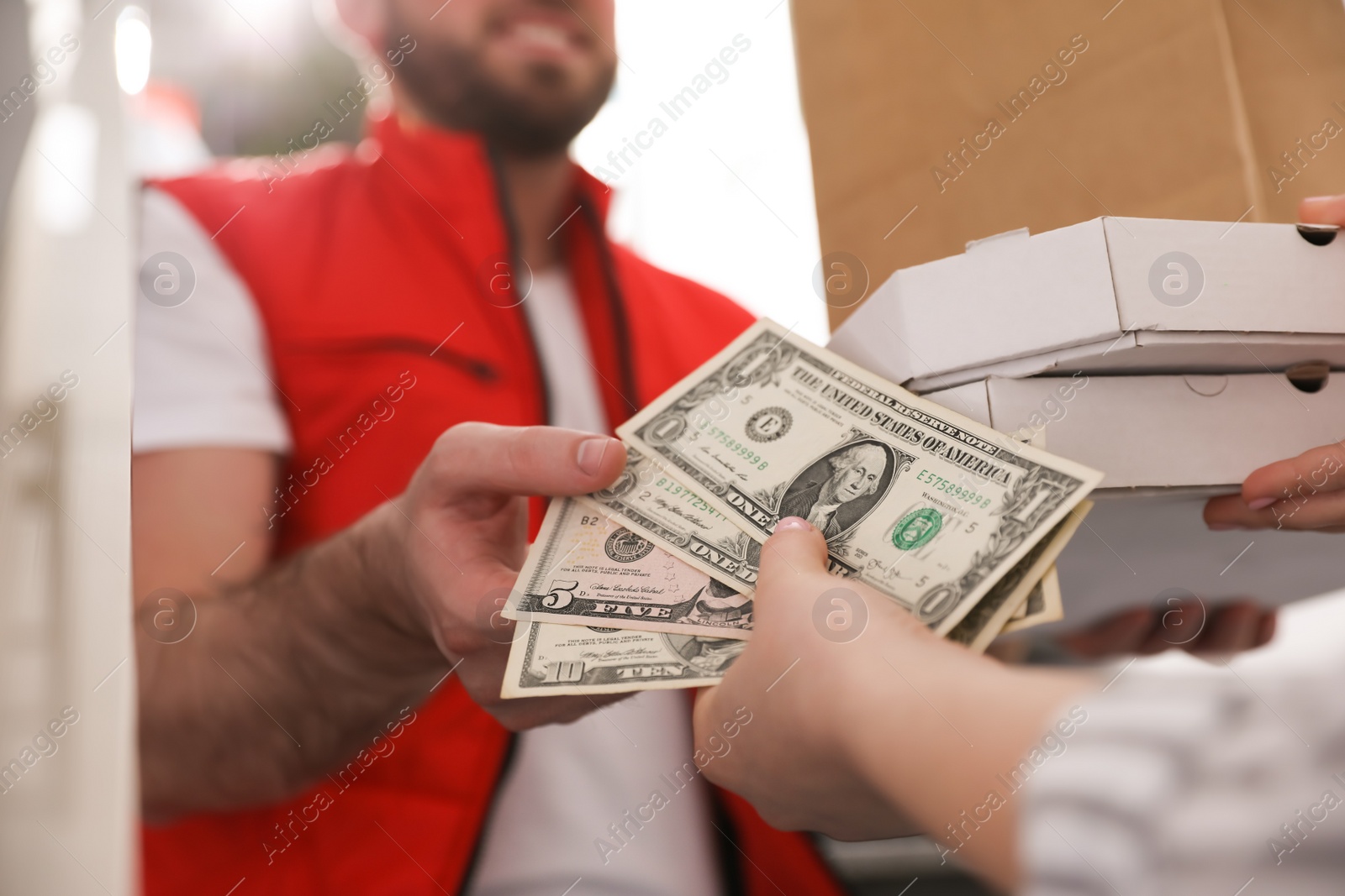 Photo of Deliveryman receiving tips from woman indoors. closeup