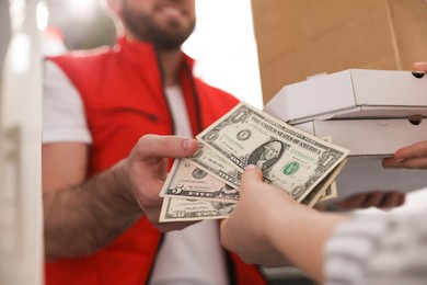 Deliveryman receiving tips from woman indoors. closeup