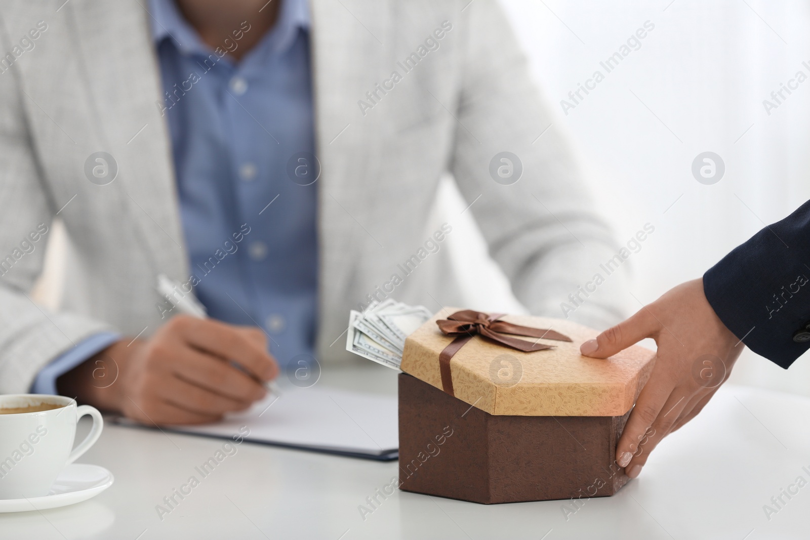 Photo of Woman giving bribe to man at table in office, closeup