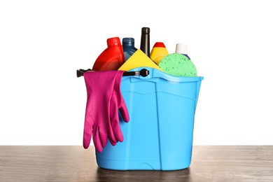 Photo of Light blue bucket and many different car wash products on black wooden table against white background