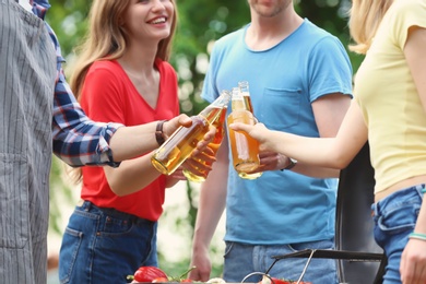 Young people with bottles of beer outdoors. Summer picnic