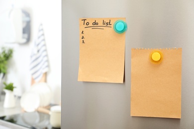 Photo of To do list and empty sheet of paper with magnets on refrigerator door in kitchen. Space for text