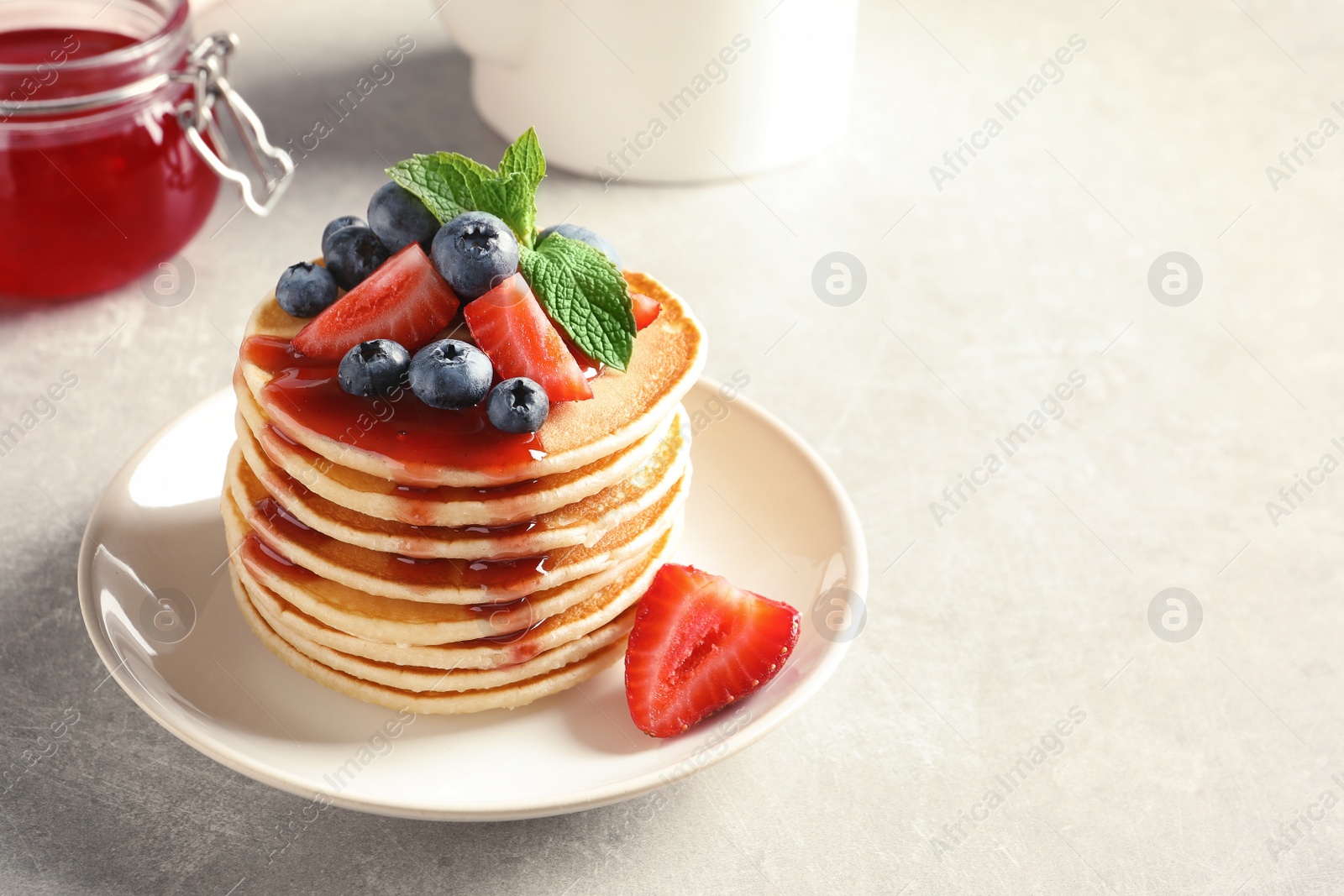 Photo of Plate with pancakes and berries on table