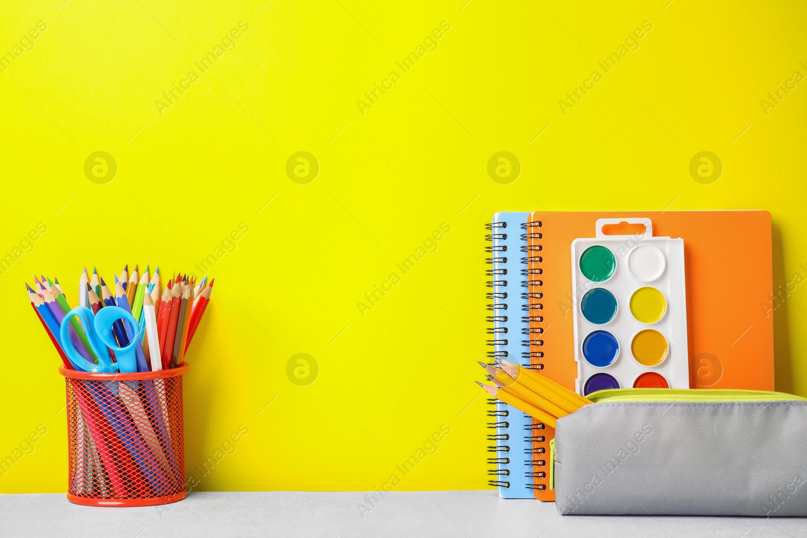 Photo of Different school stationery on white table against yellow background, space for text. Back to school