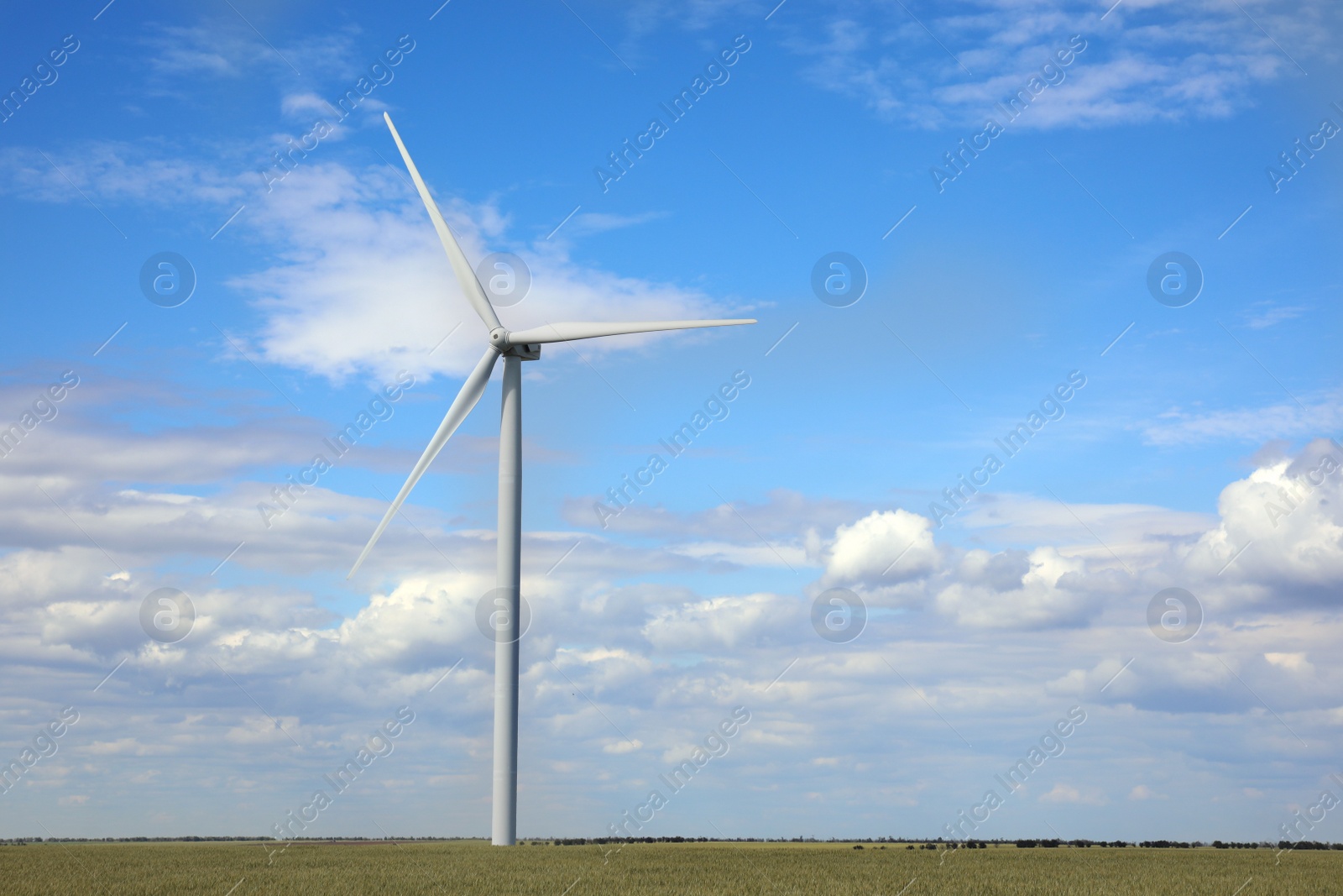 Photo of Beautiful view of field with wind turbine. Alternative energy source