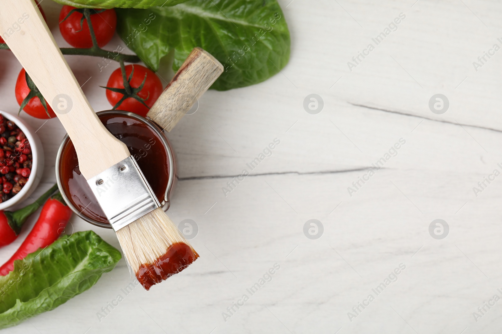 Photo of Flat lay composition with marinade, products and basting brush on white wooden table. Space for text