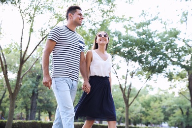 Lovely couple walking together in park on sunny day