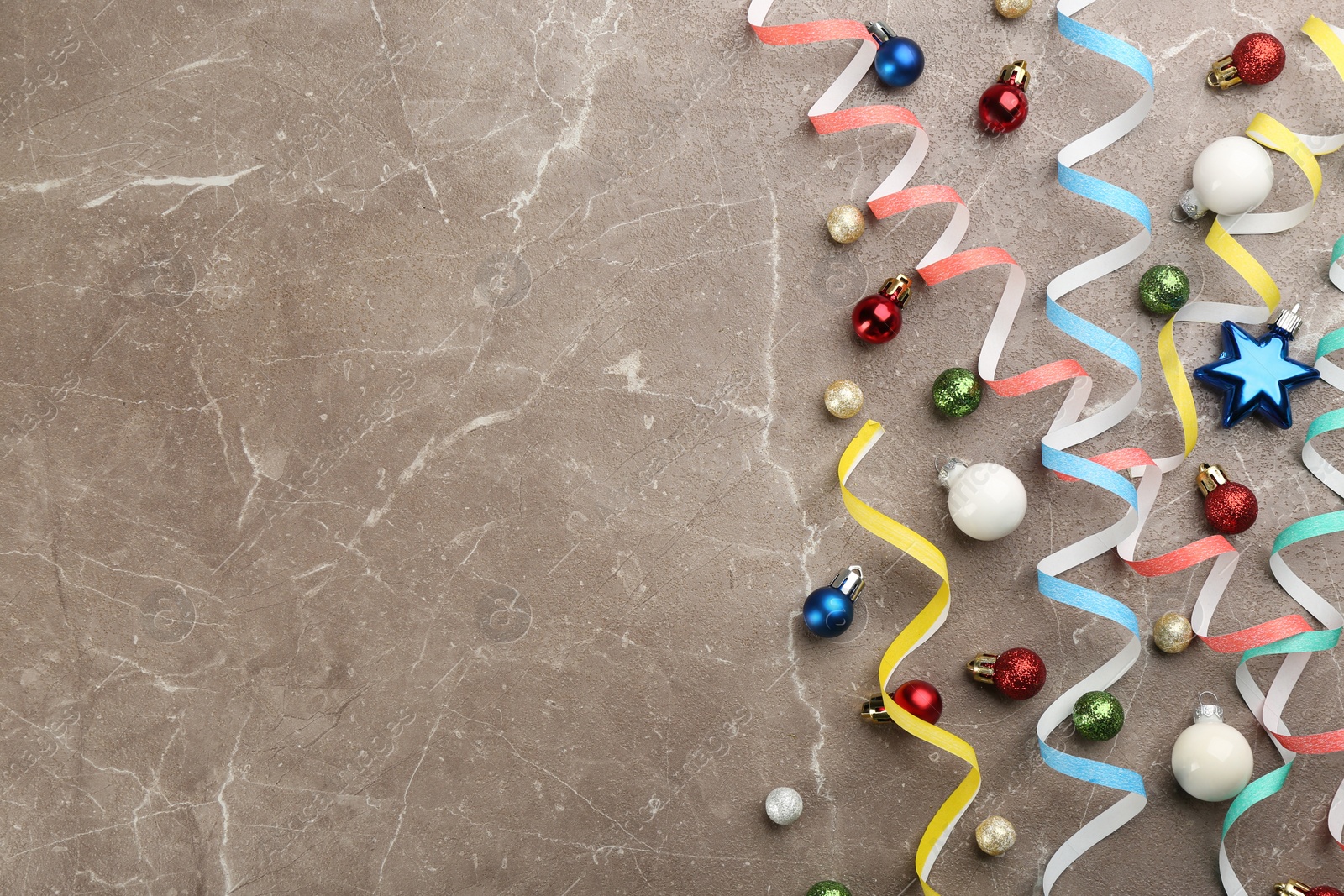 Photo of Flat lay composition with serpentine streamers and Christmas decor on grey background. Space for text