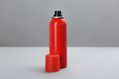 Bottle with insect repellent spray on grey background