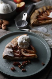 Photo of Delicious apple galette with ice cream and pecans on wooden table