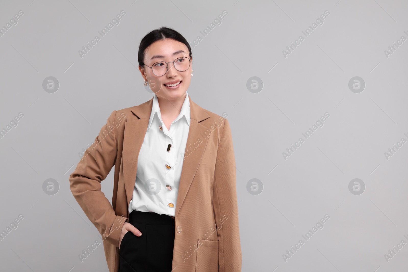 Photo of Portrait of smiling businesswoman on grey background. Space for text