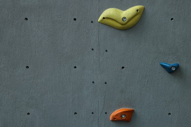 Photo of Colorful climbing wall with holds. Extreme sport