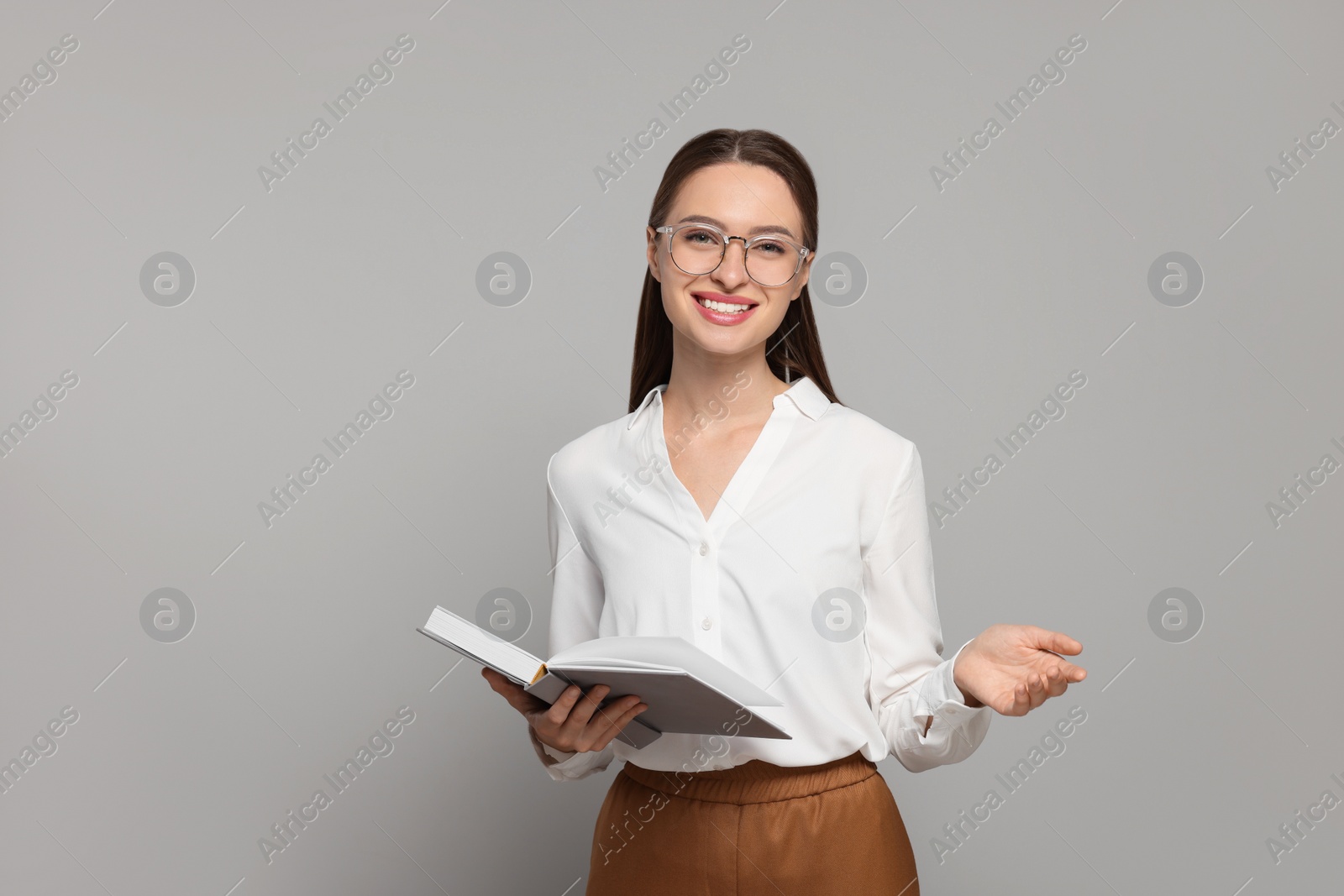 Photo of Portrait of beautiful young teacher on grey background