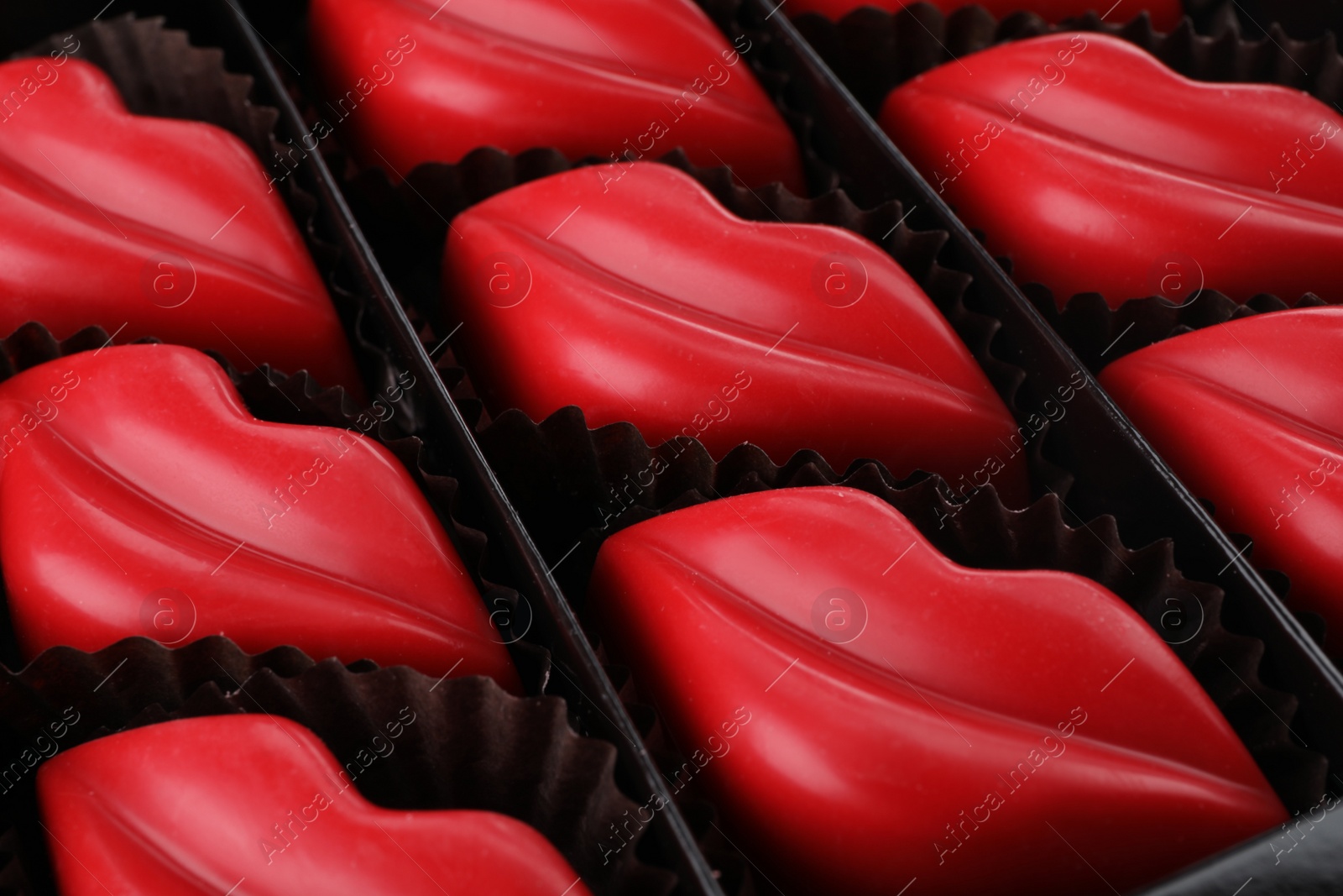 Photo of Delicious lip shaped chocolate candies in box, closeup