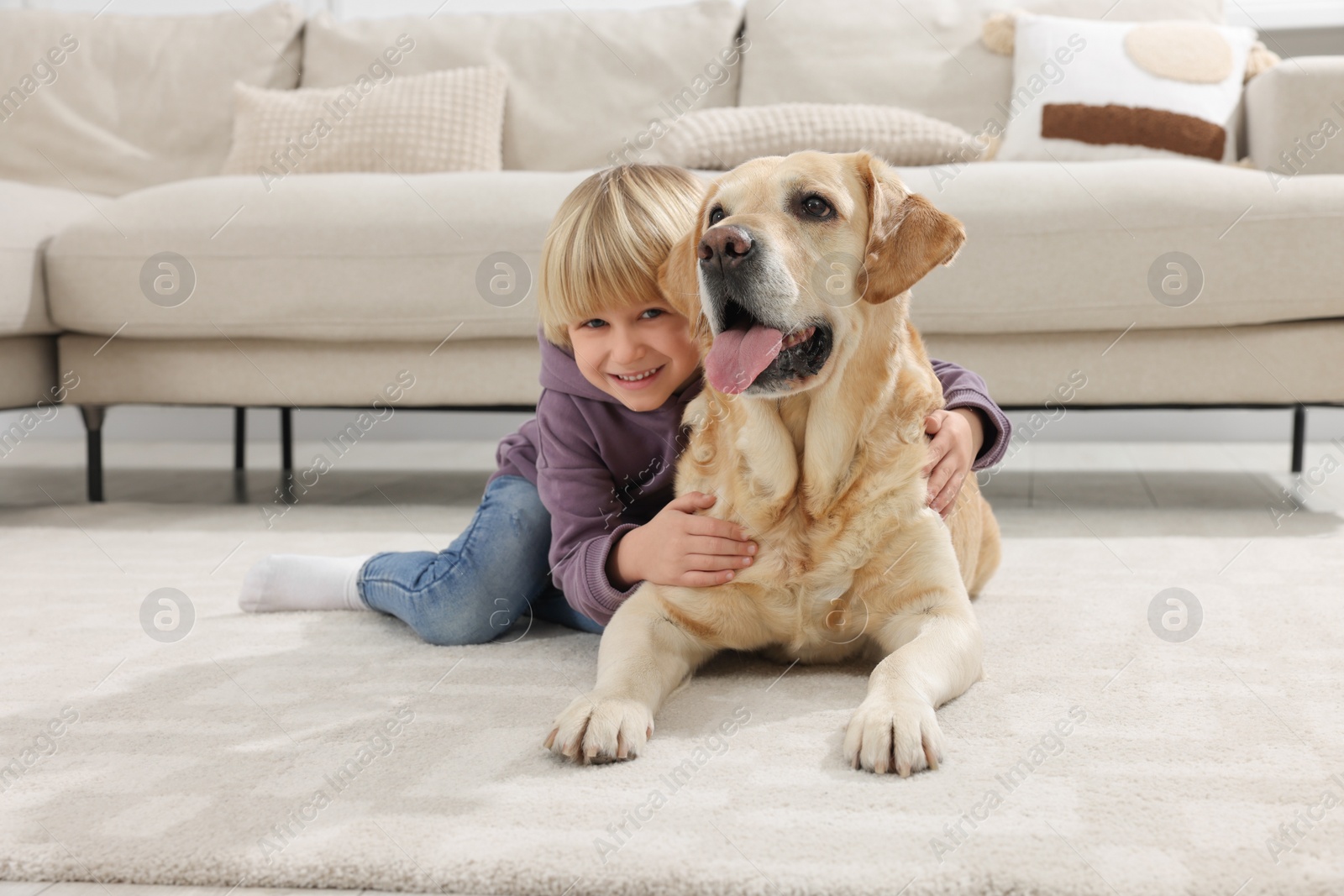 Photo of Cute little child with Golden Retriever on floor at home. Adorable pet