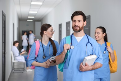 Photo of Smart medical student with book in college hallway