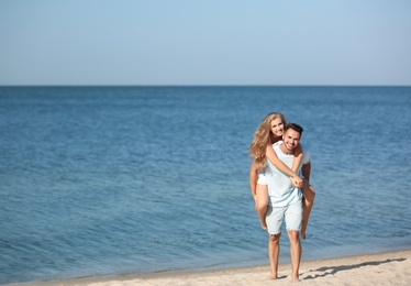 Happy young couple at beach on sunny day