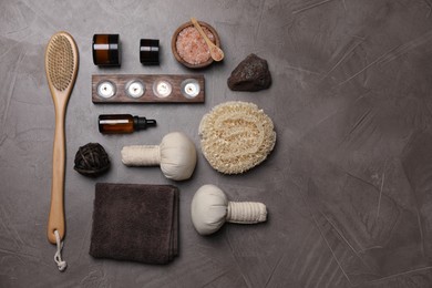 Photo of Flat lay composition with different spa products and burning candles on grey textured table. Space for text