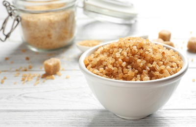 Photo of Bowl with brown sugar on wooden table