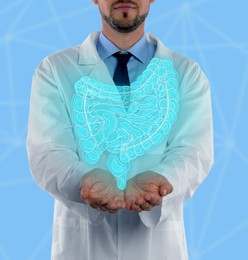 Gastroenterologist holding illustration of intestines on light blue background, closeup