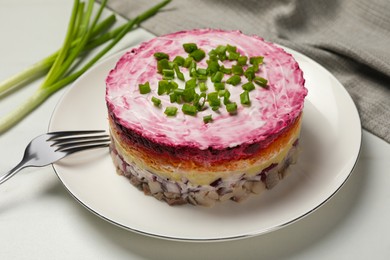 Photo of Herring under fur coat salad served on white table. Traditional Russian dish