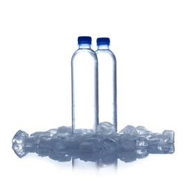Photo of Bottles of water and ice cubes on white background