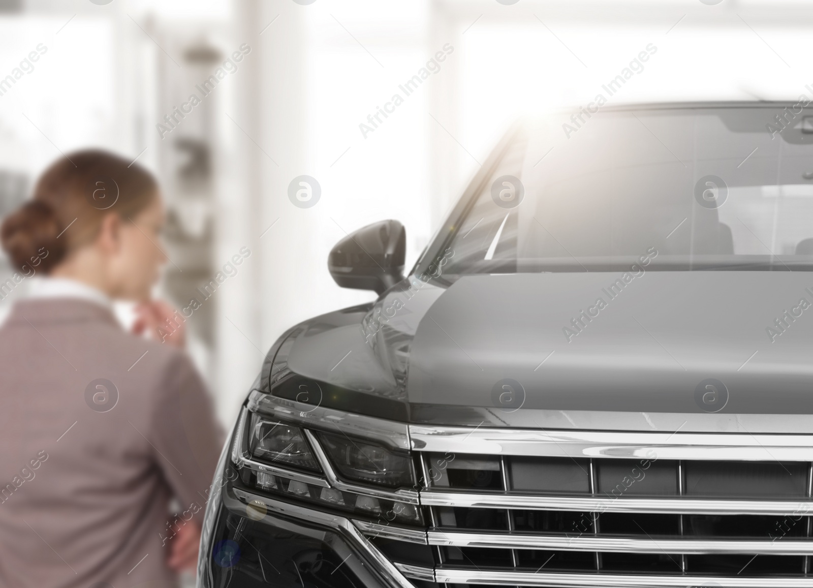 Image of Customer choosing and buying car in auto dealership, focus on new auto