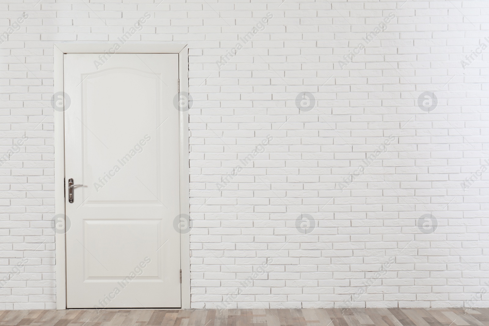 Photo of Closed white wooden door in brick wall