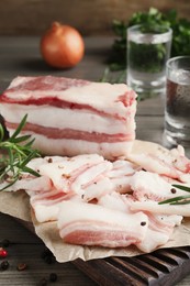 Tasty salt pork with rosemary and pepper on wooden table