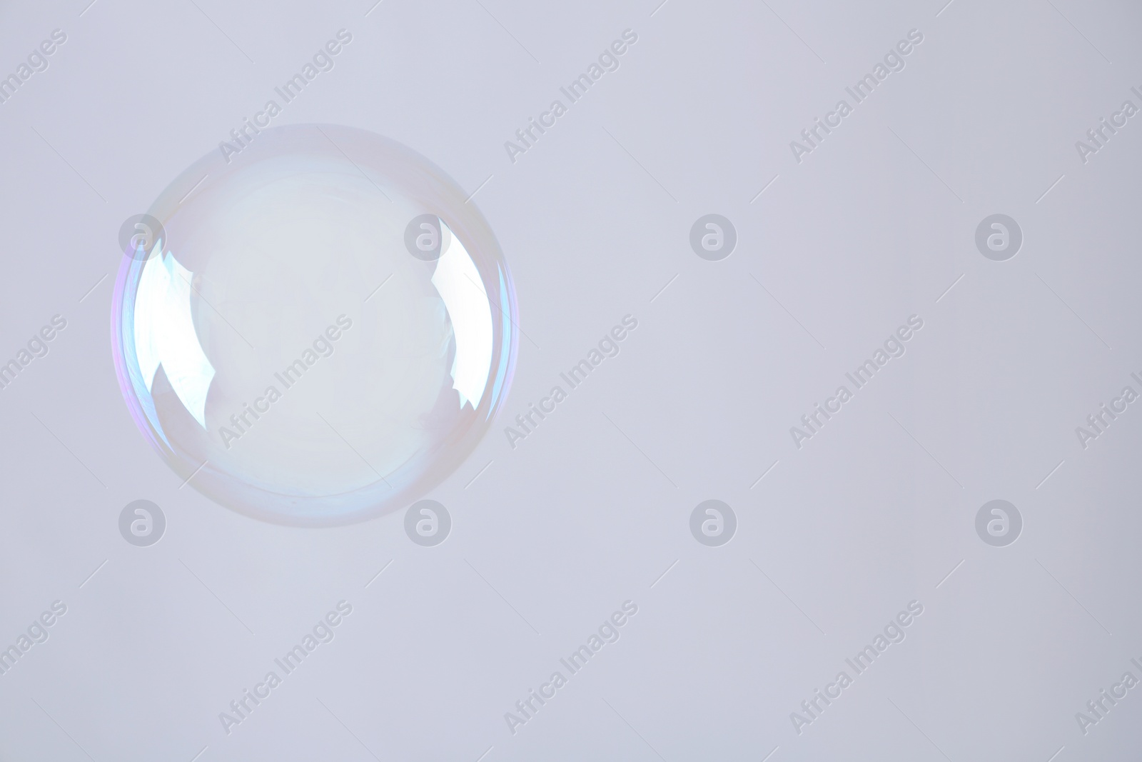 Photo of Beautiful translucent soap bubble on grey background. Space for text