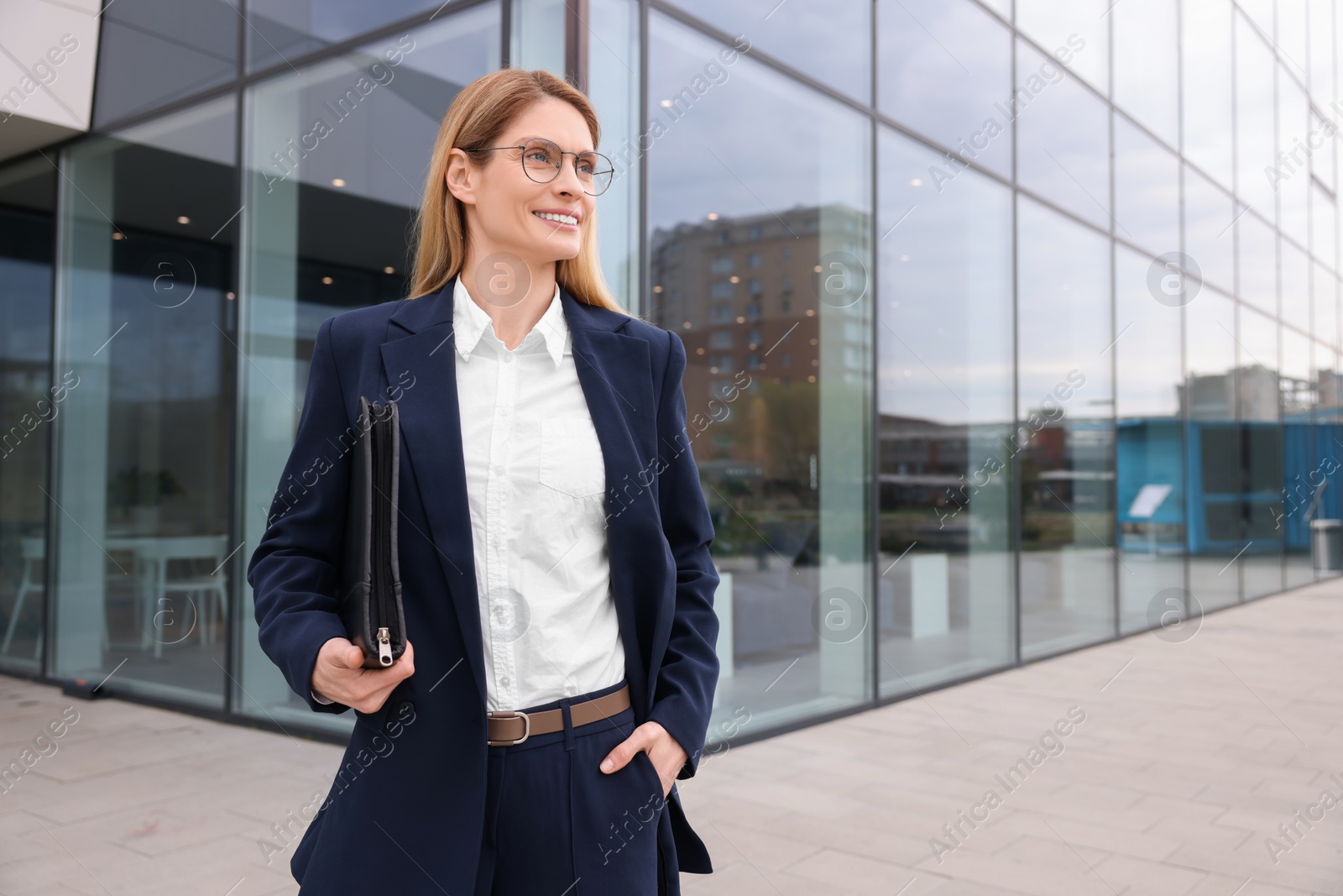 Photo of Female real estate agent with leather portfolio outdoors