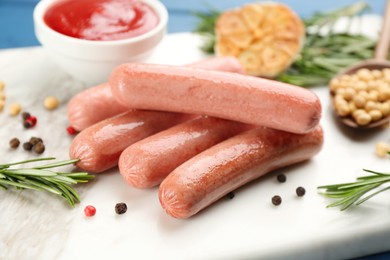Photo of Delicious vegetarian sausages with rosemary and pepper on white marble board, closeup