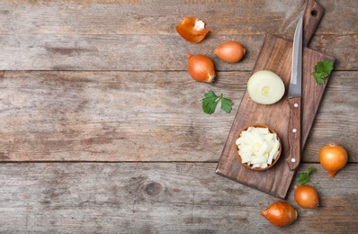 Flat lay composition with fresh ripe onions on wooden table