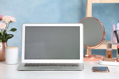 Photo of Modern laptop and phone on white table