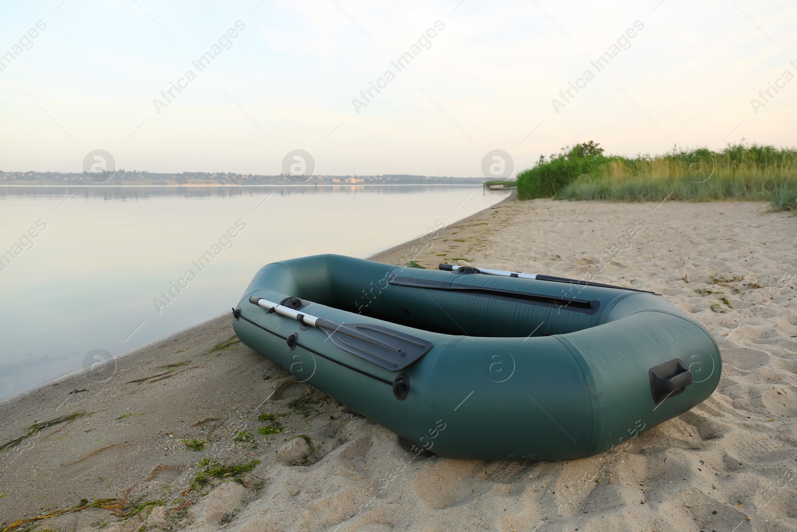 Photo of Inflatable rubber fishing boat on sandy beach near river