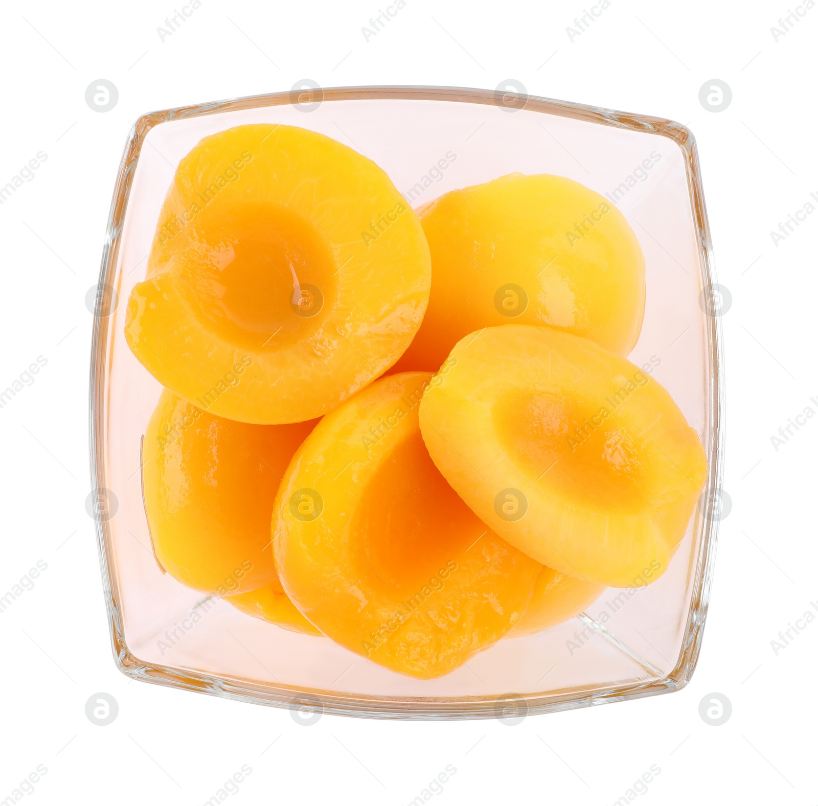 Photo of Halves of canned peaches in bowl isolated on white, top view