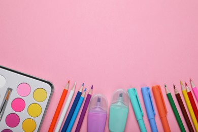 Photo of Watercolor palette, colorful markers and pencils on pink background, flat lay. Space for text