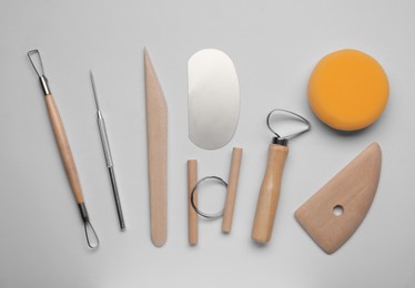 Photo of Set of clay modeling tools on white background, flat lay