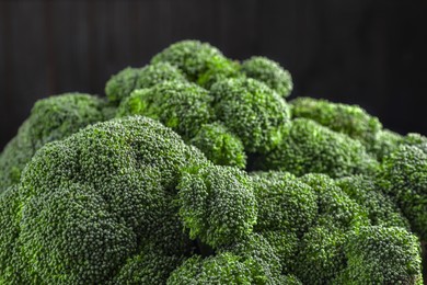 Photo of Fresh raw broccoli on dark background, closeup