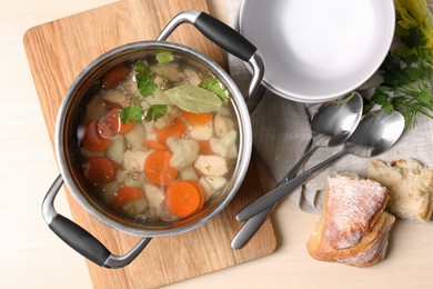 Photo of Delicious vegetable bouillon served on wooden table, flat lay