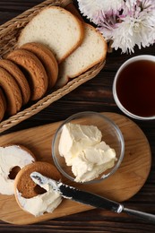 Tasty homemade butter, cookies and tea on wooden table, flat lay