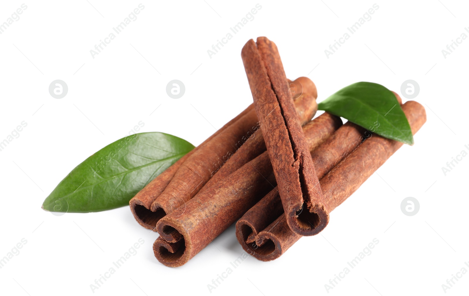 Photo of Cinnamon sticks and green leaves isolated on white
