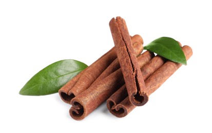 Photo of Cinnamon sticks and green leaves isolated on white