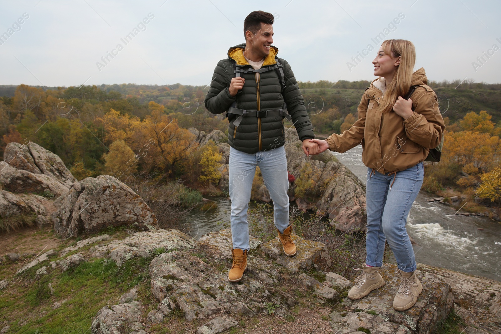 Photo of Couple of hikers with backpacks in mountains on autumn day