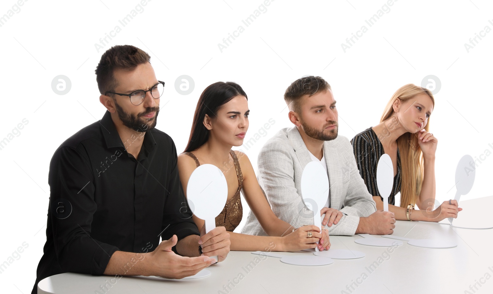 Photo of Panel of disappointed judges holding blank score signs at table on white background. Space for text